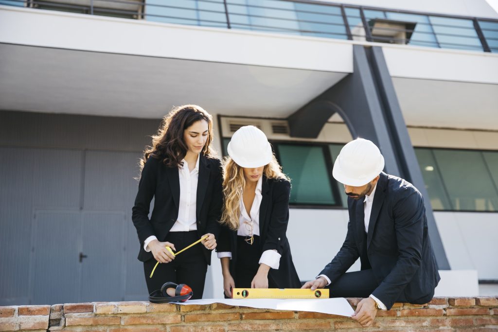 three architects wearing helmets